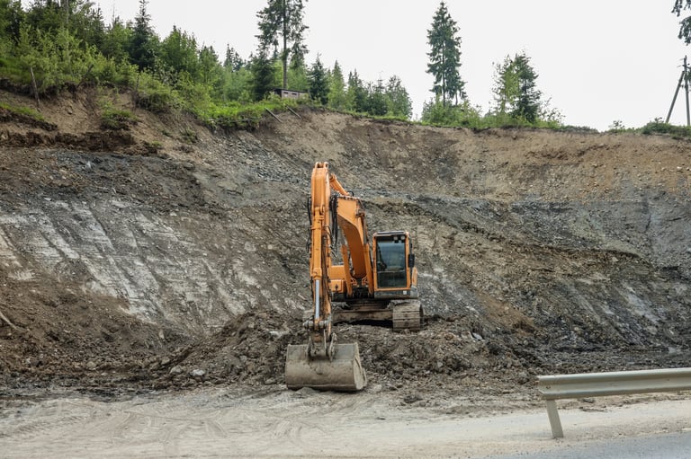 Excavator working on rocky slope